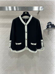 Knitted cardigan with seven-quarter sleeves in black and white.